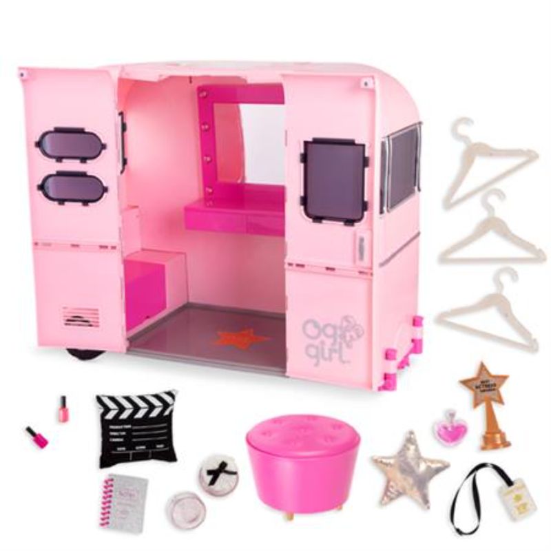 Bright pink movie trailer for 18-inch dolls with foldout bed, working lights, vanity, and styling accessories for imaginative play.