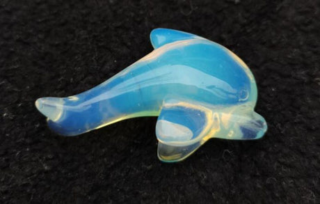 Dolphin-shaped opalite gemstone, 5cm, showcasing iridescent colors and symbolizing tranquility and emotional healing.