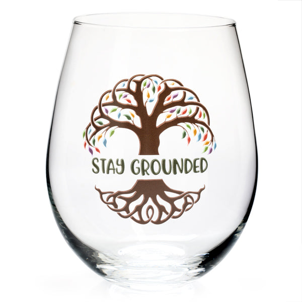 Hand-blown stemless glass featuring a Celtic tree of life design with rainbow leaves and the phrase "stay grounded."