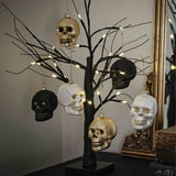 Three uniquely designed skull-shaped ornaments in black, white, and gold for elegant Halloween decor.