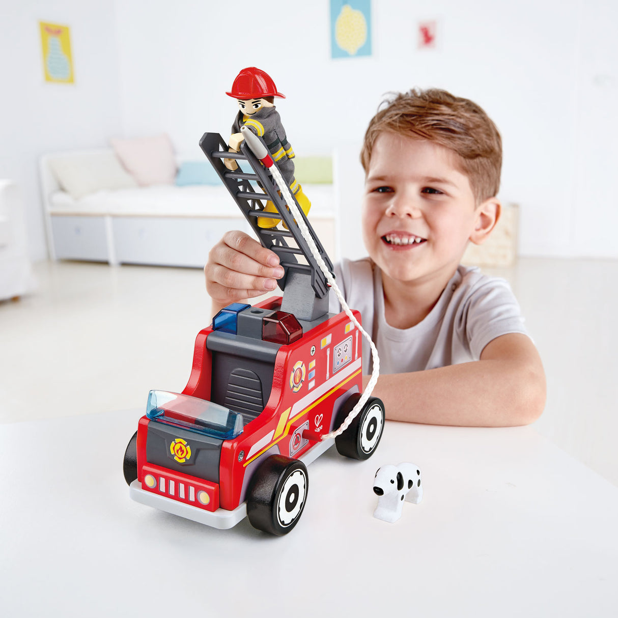 Colorful wooden Hape Fire Truck with an expandable ladder and firefighter figure, perfect for adventurous imaginative play.