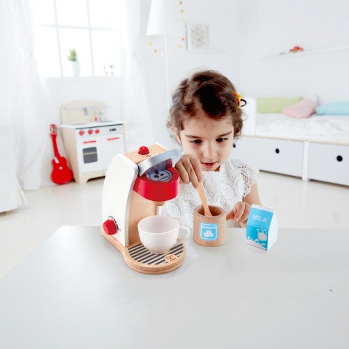 A colorful toy coffee machine set for kids, complete with cup, milk, sugar, and coffee pod for imaginative play.