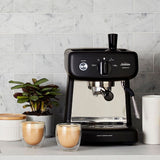 Compact black espresso machine with 15-bar pump, 2L tank, and included accessories for café-style drinks at home.