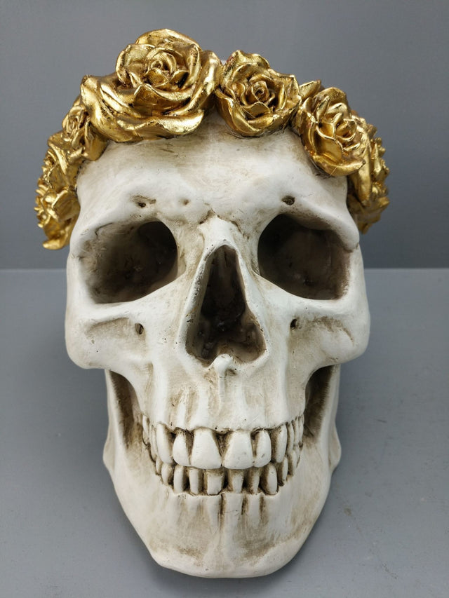 White skull figurine adorned with intricate gold roses, perfect for gothic decor and elegant home accents.