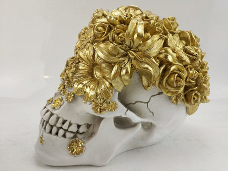 Stunning skull sculpture adorned with delicate gold flowers, perfect for gothic decor and a captivating home centerpiece.