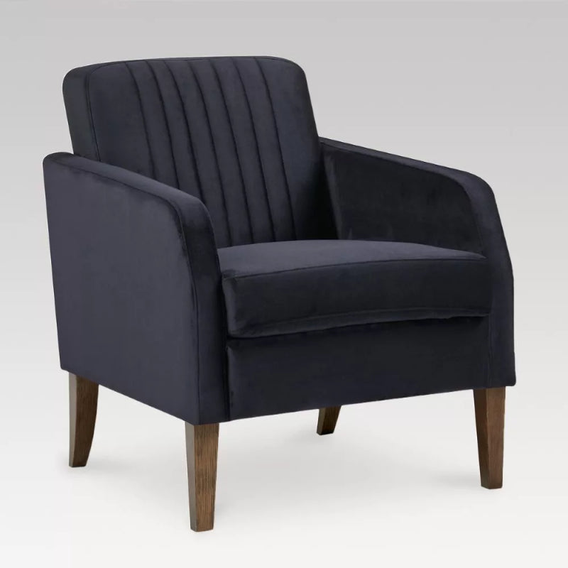 "Elegant black Makers Batten Chair with velvet upholstery, high-density cushions, and sturdy wood frame for stylish comfort."