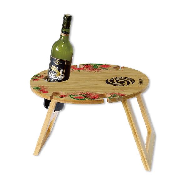 Stylish Koru bamboo outdoor table holds one wine bottle and four glasses, lightweight and perfect for picnics and beach trips.