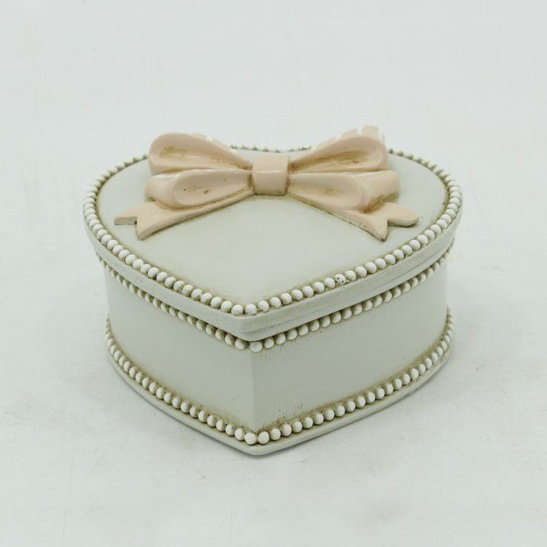 Elegant heart-shaped jewelry box with a bow lid, perfect for storing rings and necklaces, adding charm to your decor.