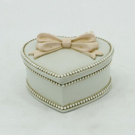 Elegant heart-shaped jewelry box with a bow lid, perfect for storing rings and necklaces, adding charm to your decor.