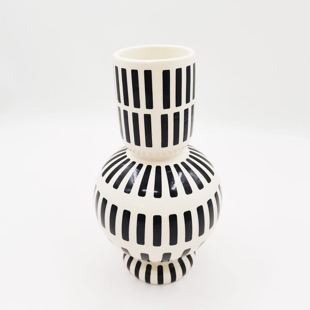 Modern dolomite vase with striking black line design, perfect for flowers or as a chic decor statement piece.