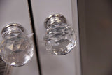 Elegant mirrored cabinet with bevelled surfaces and crystal knobs, perfect for stylish storage in any room.