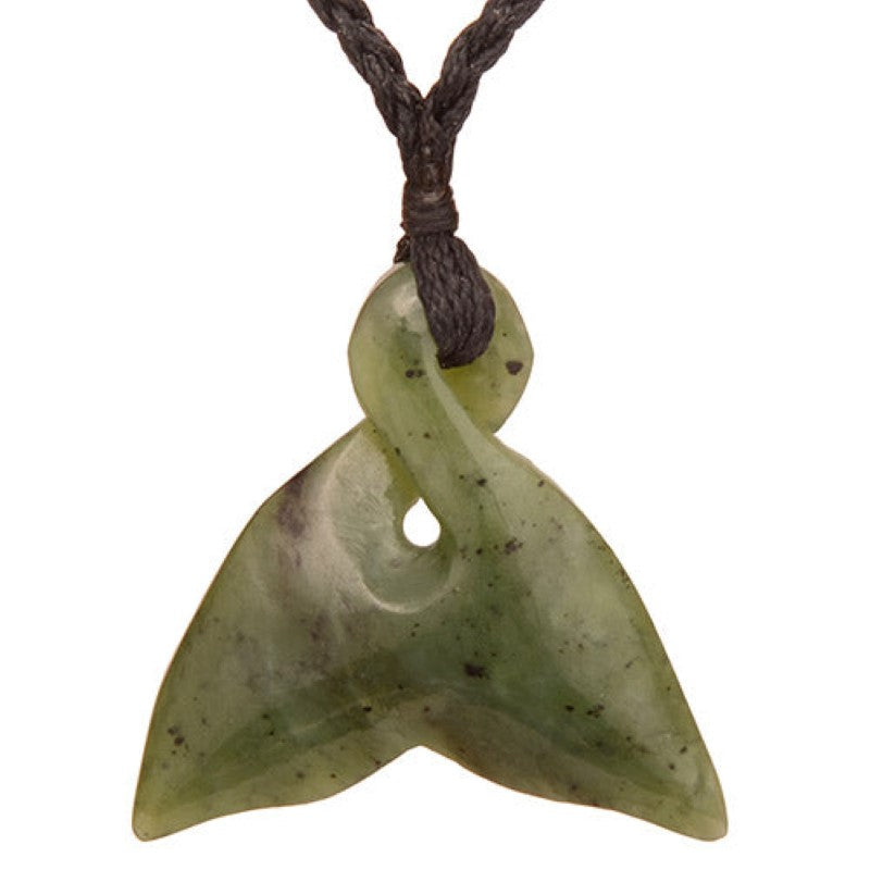 Jade whale tail twist pendant necklace on a black braided cord, symbolizing life's journey and Maori cultural heritage.