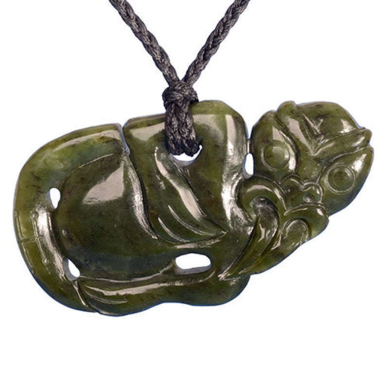 Jade Tiki pendant measuring 84x45 mm, hand-carved, on adjustable black cord, symbolizing good luck and fertility.