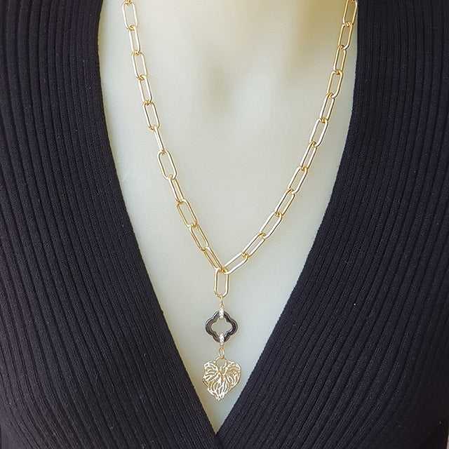 KC gold plated paperclip chain necklace with a nature-inspired Kawakawa leaf charm, featuring a gold flower toggle clasp.