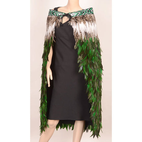 Emerald green Korowai cloak adorned with taniko trim, symbolizing M?ori culture, handmade with feathers in New Zealand.