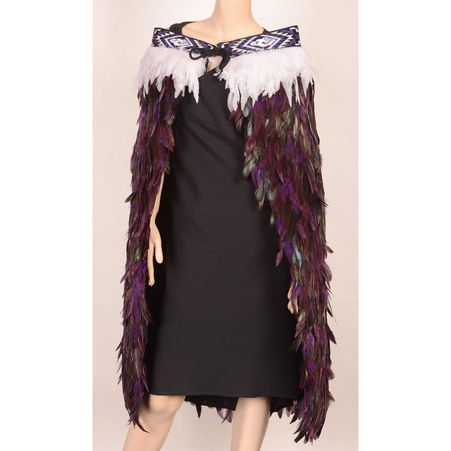 Handmade purple Korowai cloak with feather embellishments and taniko trim, symbolizing M?ori heritage and spiritual connection.