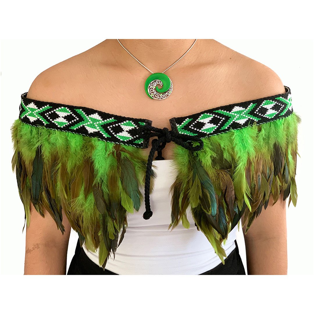 Traditional green Korowai cape featuring intricate kowhaiwhai design, perfect for evening wear and special occasions.