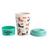 Bamboo travel cup featuring dachshunds on blue, with anti-spill lid and silicone band for eco-friendly sipping.