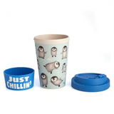 Eco-friendly bamboo travel cup featuring dancing penguins, a blue lid, and a 'Just Chillin' silicone band.