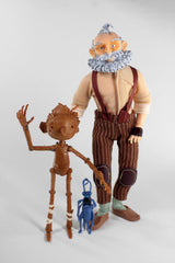 Collectible figurine set featuring Geppetto, Pinocchio, and Cricket from Guillermo del Toro's animated film, with detailed clothing.