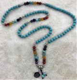 Chakra Mala Necklace made of turquoise howlite, 70cm long, promotes calmness, patience, and personal growth in a stylish design.