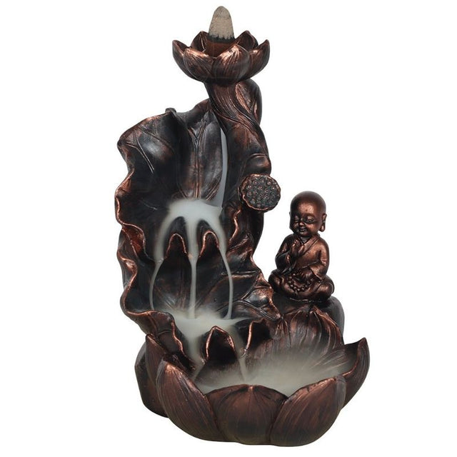 Serene Buddha surrounded by oversized lotus flowers on a bronze backflow incense burner, creating a calming atmosphere.