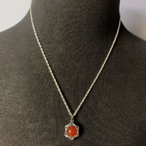 Carnelian star pendant featuring a vibrant gemstone, designed to inspire motivation and enhance confidence.