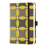 Elegant Castelli Oro notebook with textured weave, geometric designs, ruled pages, gold ribbon marker, and eco-friendly features.