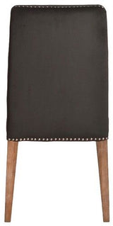 Dark grey velvet dining chair with antique studs, solid timber frame, blending modern luxury with classic elegance.