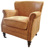 Distressed camel leather armchair with brass nails, oak legs, and high-density foam; perfect for stylish comfort in any space.