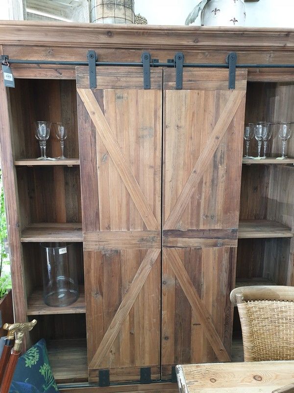 Rustic bar and wine unit with sliding doors, crafted from reclaimed pine and iron, perfect for stylish beverage storage.