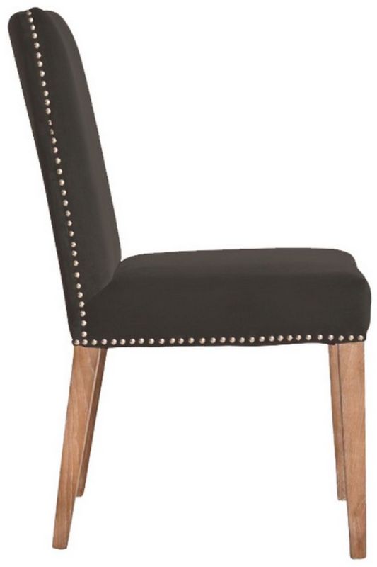 Dark grey velvet dining chair with antique studs and solid timber frame, blending luxury and elegance for any dining space.