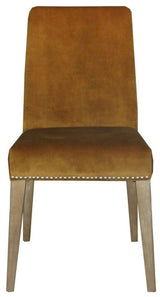 Mustard velvet dining chair with antique studs, solid timber frame, blending luxury and sophistication for dining spaces.