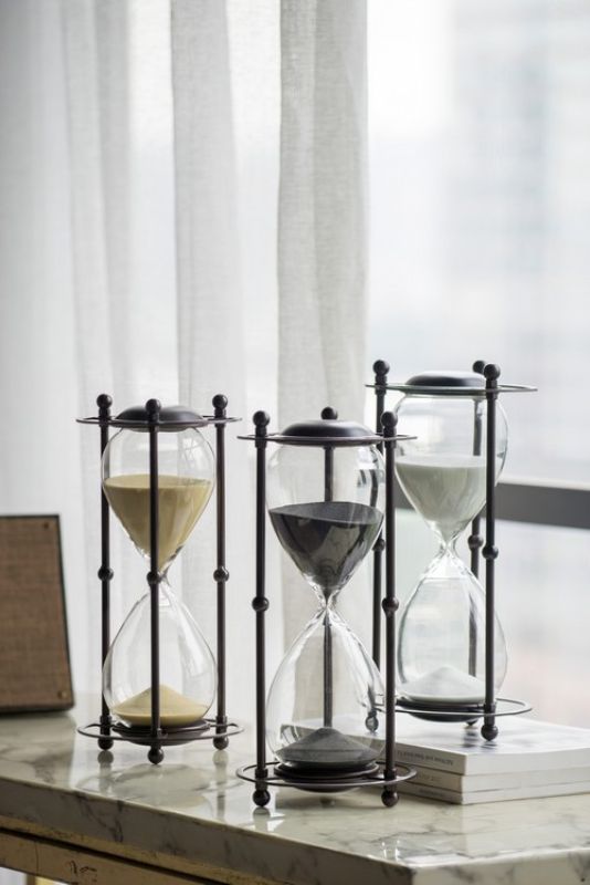 Elegant black hourglass with iron stand, perfect for home or office decor, measuring 15.8x15.8x33cm.