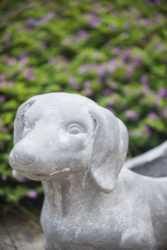 Whimsical dog-shaped planter in neutral gray, perfect for indoor or outdoor plants, crafted from durable fibreglass resin.