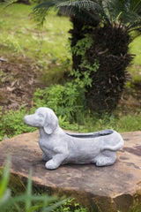 Whimsical dog-shaped planter in gray, perfect for indoor/outdoor blooms, herbs, or succulents; made of durable fibreglass resin.