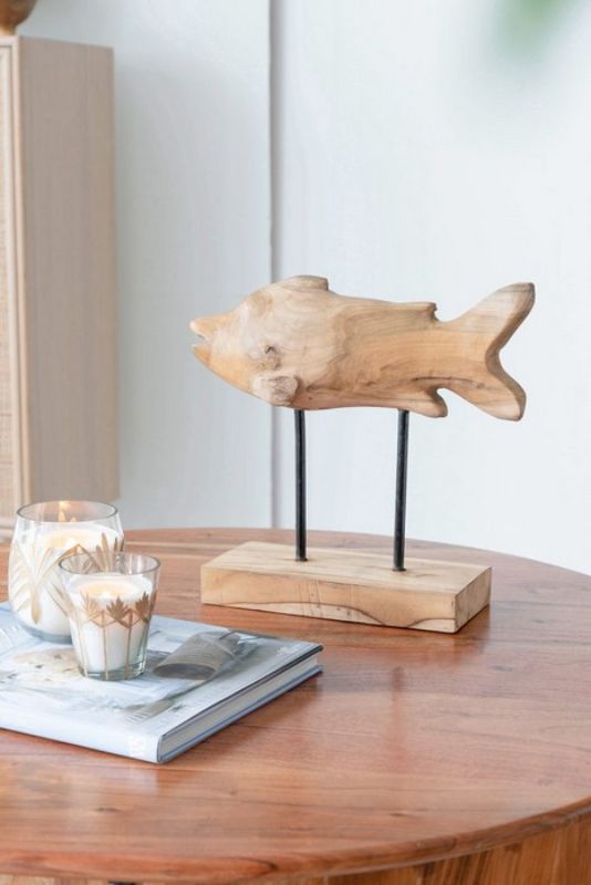 Handcrafted teak fish sculpture on stand, showcasing natural grain; adds rustic charm to modern decor.