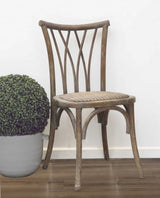 Elegant dining chair in antique oak with elm wood frame and woven rattan seat, perfect for rustic or historical settings.