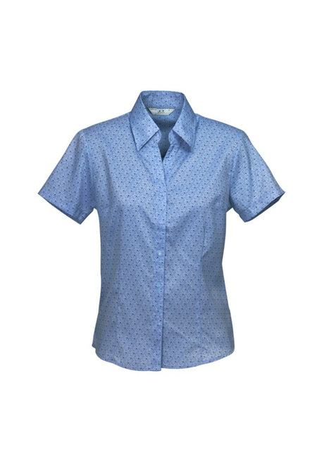 Ladies mid blue short sleeve shirt with open neckline, twin pleats, and curved hem, crafted from breathable performance fabric.