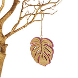 Hanging ornament featuring a vibrant pink satin Monstera leaf design, crafted from durable bamboo and acrylic, ready to hang.