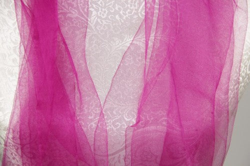 Luxurious fuchsia 100% silk wrap with tassels, perfect for elegant layering and versatile styling.