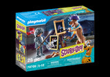 Playmobil SCOOBY-DOO! set featuring Scooby-Doo, Black Knight, ghost card, and painting accessories for adventurous mystery play.