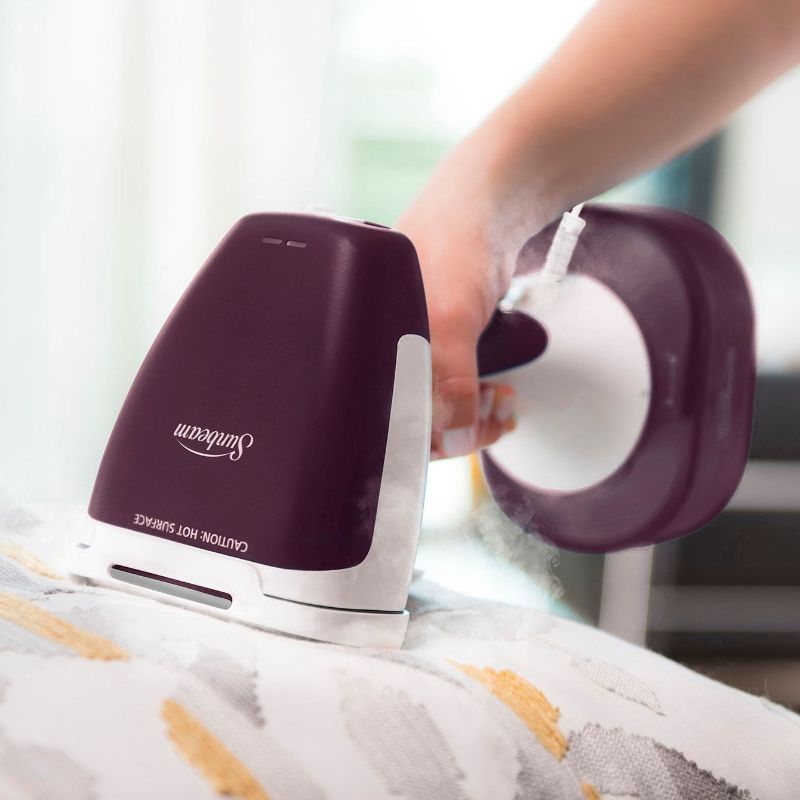 Purple handheld garment steamer with 1400 watts, 300ml tank, four accessories, and quick 40-second heat-up for wrinkle-free clothes.