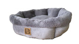 Cozy grey round pet bed with overstuffed sides, soft faux suede, and a non-slip base for ultimate comfort and style.