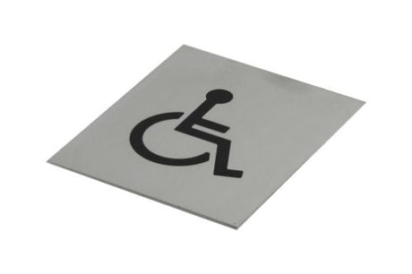 Black adhesive wheelchair symbol on brushed stainless steel, 120x100mm, designed for accessibility in stylish public spaces.