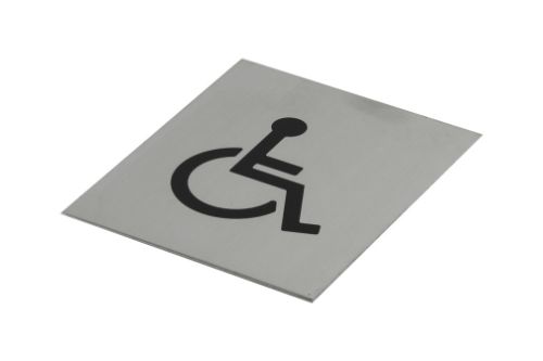 Black adhesive wheelchair symbol on brushed stainless steel, 120x100mm, designed for accessibility in stylish public spaces.