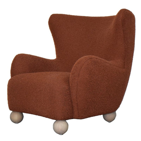 Rust-colored OLIVER CHAIR with overstuffed arms, contoured seat, and solid wood frame for stylish comfort in modern interiors.