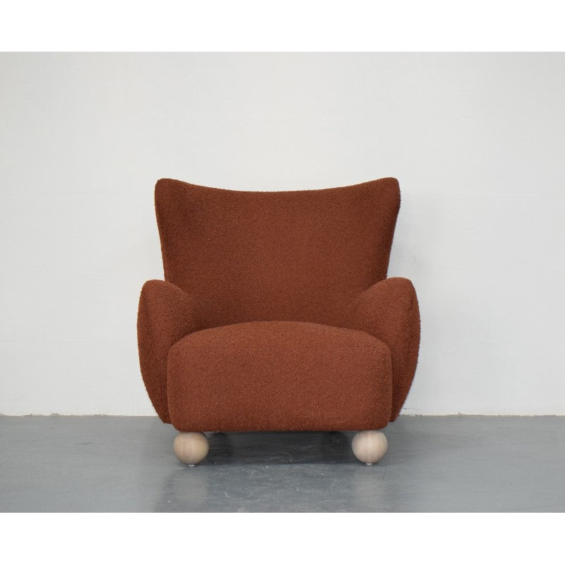 Stylish rust accent chair with overstuffed arms and contoured seat, perfect for modern interiors and relaxation.