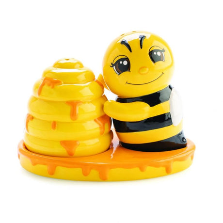 Charming salt and pepper set shaped like a bee and beehive, complete with a golden honey drip tray for stylish seasoning.