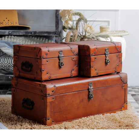Set of 3 vintage leather trunks in varying sizes, perfect for stylish storage and enhancing home decor.